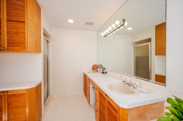 991 W Park Ave, Long Beach, NY 11561 - bathroom featuring double vanity, a shower with shower door, tile patterned flooring, recessed lighting, and tile walls