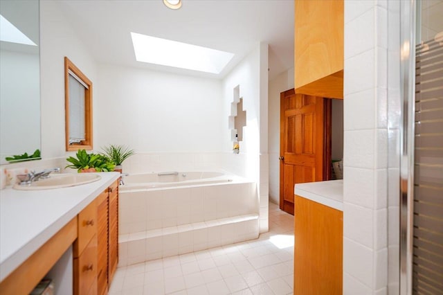 991 W Park Ave, Long Beach, NY 11561 - bathroom featuring a skylight, vanity, tile patterned floors, and a garden tub