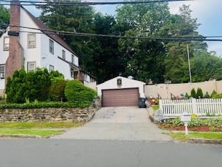 1 Spencer Ct, Hartsdale, NY 10530 - view of front of property with an outdoor structure, a garage, and a chimney