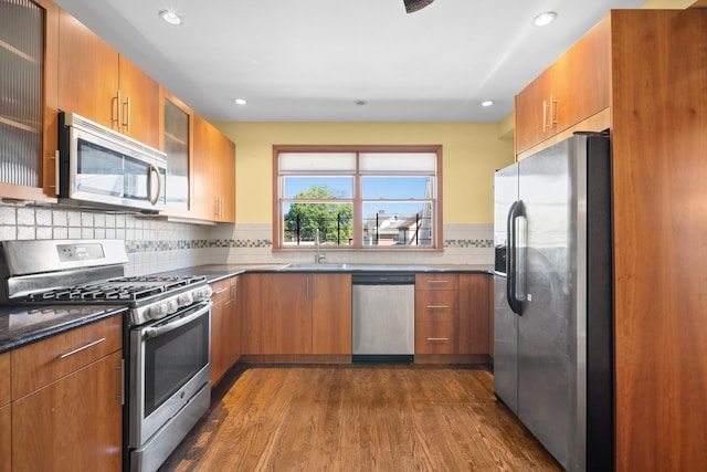 40-40 203rd St Unit 12B, Bayside, NY 11361 - kitchen featuring stainless steel appliances, dark wood-style flooring, brown cabinetry, a sink, and recessed lighting
