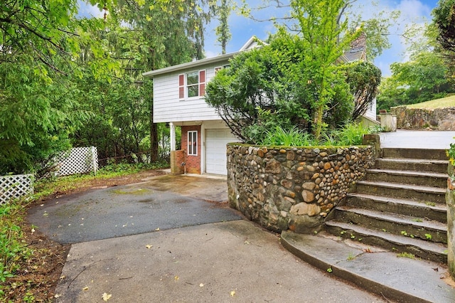 5 Murray Hill Rd, Sound Beach, NY 11789 - view of front of house featuring driveway, an attached garage, brick siding, and stairs