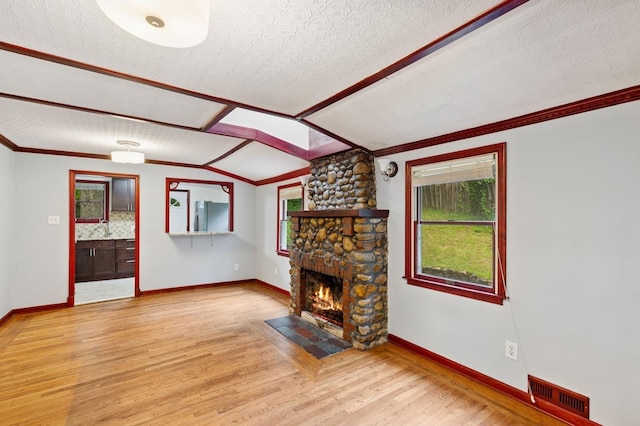 5 Murray Hill Rd, Sound Beach, NY 11789 - unfurnished living room featuring a stone fireplace, wood finished floors, baseboards, vaulted ceiling, and crown molding