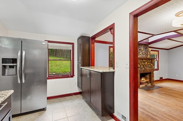 5 Murray Hill Rd, Sound Beach, NY 11789 - kitchen with stainless steel refrigerator with ice dispenser, dark brown cabinets, baseboards, a fireplace, and light stone countertops