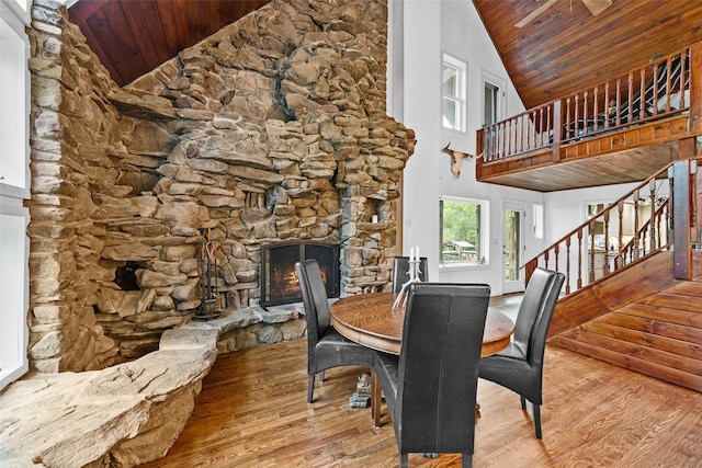 281 Hubert Rd, Jeffersonville, NY 12748 - dining area with wood ceiling, wood finished floors, high vaulted ceiling, a stone fireplace, and stairway