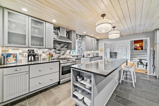 281 Hubert Rd, Jeffersonville, NY 12748 - kitchen with stainless steel appliances, wall chimney exhaust hood, gray cabinets, wood ceiling, and a breakfast bar area