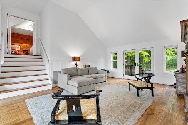 281 Hubert Rd, Jeffersonville, NY 12748 - living area with stairway, french doors, wood finished floors, high vaulted ceiling, and a wainscoted wall