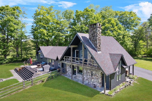 281 Hubert Rd, Jeffersonville, NY 12748 - back of property featuring a chimney, stone siding, a yard, a wooden deck, and roof with shingles