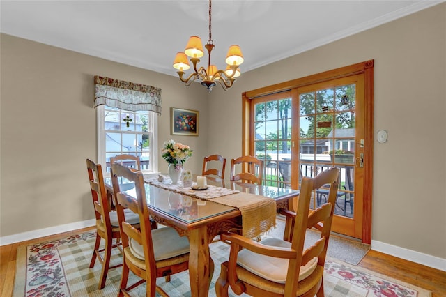 170 Little E Neck Rd S, Babylon, NY 11702 - dining room with healthy amount of natural light, baseboards, a chandelier, ornamental molding, and light wood-style flooring