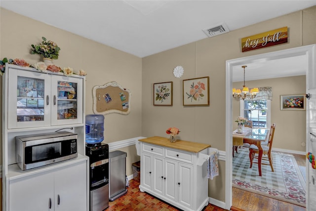 170 Little E Neck Rd S, Babylon, NY 11702 - kitchen featuring stainless steel microwave, a chandelier, white cabinetry, light countertops, and baseboards