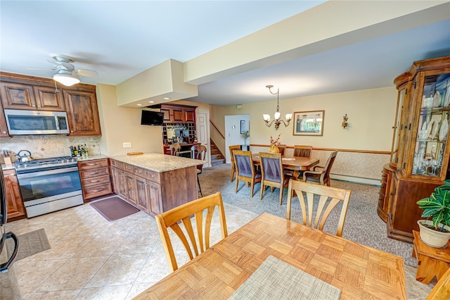 964 Manor Ln, Bay Shore, NY 11706 - kitchen featuring stainless steel appliances, a peninsula, a baseboard heating unit, tasteful backsplash, and a chandelier