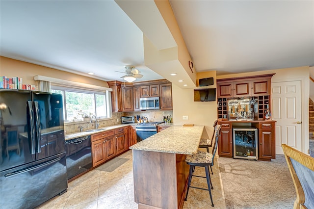 964 Manor Ln, Bay Shore, NY 11706 - kitchen featuring black appliances, beverage cooler, a sink, a kitchen bar, and backsplash