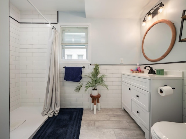 29 Chestnut St, Pearl River, NY 10965 - bathroom featuring vanity, tiled shower, toilet, wood finished floors, and tile walls