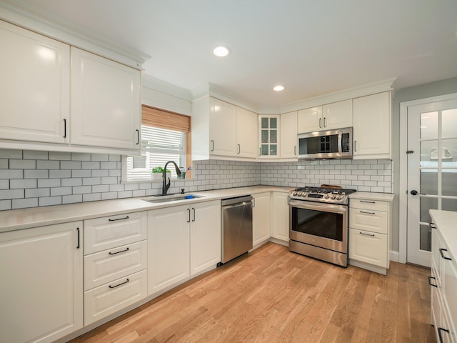 29 Chestnut St, Pearl River, NY 10965 - kitchen with appliances with stainless steel finishes, a sink, light wood finished floors, recessed lighting, and glass insert cabinets