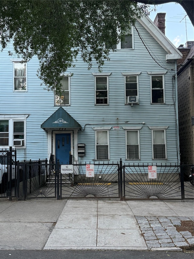 289 E 201st St, Bronx, NY 10458 - view of front of home featuring a fenced front yard, a gate, and a chimney