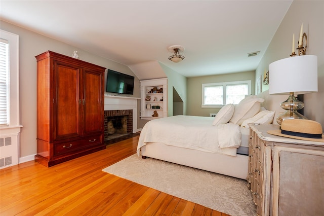 70 Loines Ave, Merrick, NY 11566 - bedroom featuring light wood-style floors, a fireplace, and radiator