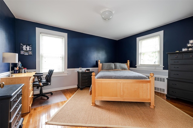 70 Loines Ave, Merrick, NY 11566 - bedroom featuring radiator, multiple windows, light wood-style floors, and an office area