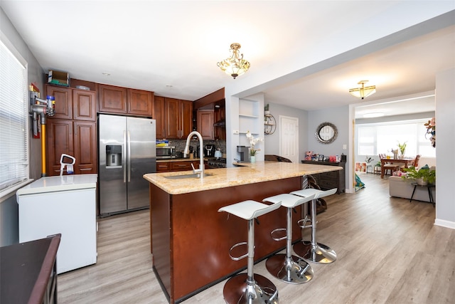 2226 124th St, College Point, NY 11356 - kitchen with appliances with stainless steel finishes, light wood-style flooring, tasteful backsplash, a kitchen breakfast bar, and a sink