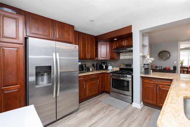 2226 124th St, College Point, NY 11356 - kitchen with appliances with stainless steel finishes, under cabinet range hood, decorative backsplash, light wood-style floors, and light stone counters
