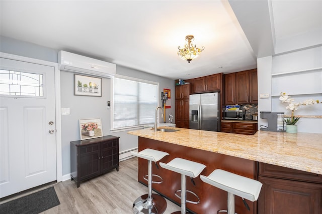 2226 124th St, College Point, NY 11356 - kitchen featuring appliances with stainless steel finishes, a sink, a wall mounted AC, a baseboard heating unit, and light wood-type flooring