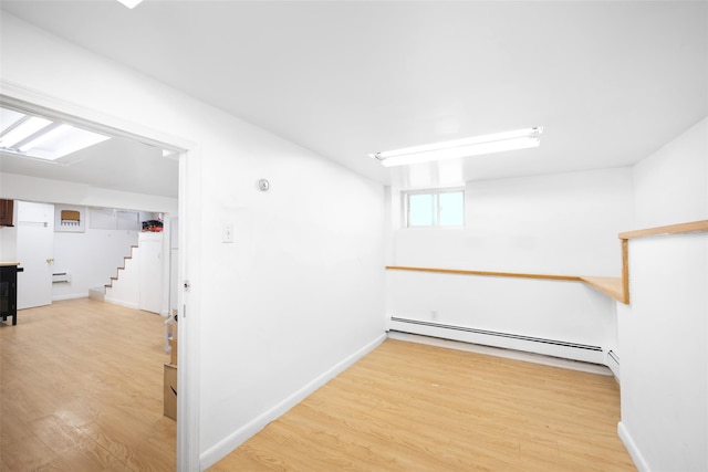 2226 124th St, College Point, NY 11356 - basement featuring a baseboard heating unit, wood finished floors, stairway, and baseboard heating