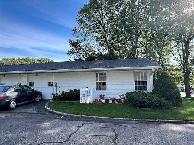411A Weymouth Ct Unit 411A, Ridge, NY 11961 - view of side of property featuring asphalt driveway, an attached garage, and a shingled roof