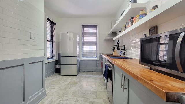 1175 Anderson Ave Unit 4D, Bronx, NY 10452 - kitchen with stainless steel appliances, wood counters, decorative backsplash, open shelves, and a sink