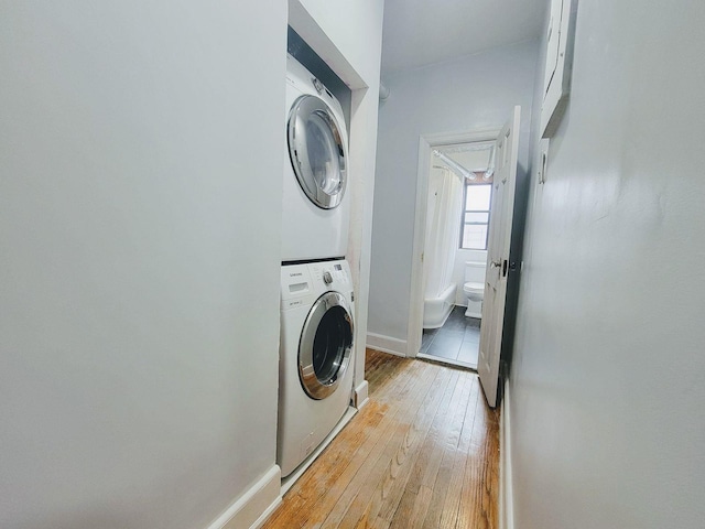 1175 Anderson Ave Unit 4D, Bronx, NY 10452 - laundry room featuring stacked washer / dryer, light wood-style floors, and baseboards