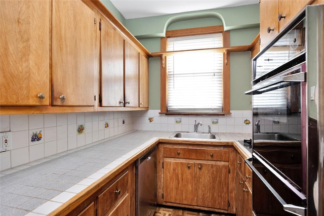 61-66 80th St, Middle Village, NY 11379 - kitchen with a sink, stainless steel dishwasher, tile counters, black oven, and decorative backsplash