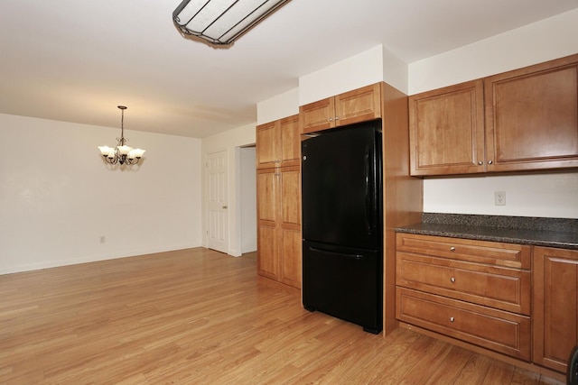 554 Kensico Ct, Suffern, NY 10901 - kitchen featuring freestanding refrigerator, dark countertops, light wood-style flooring, brown cabinetry, and a chandelier