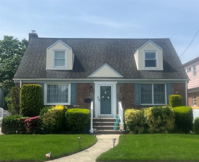 103 Woods Ave, Malverne, NY 11565 - cape cod house with a front lawn, brick siding, and a chimney