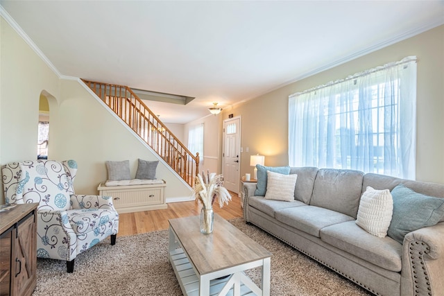 103 Woods Ave, Malverne, NY 11565 - living room with stairs, arched walkways, crown molding, light wood finished floors, and baseboards