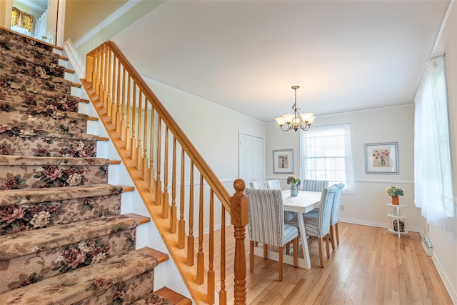 103 Woods Ave, Malverne, NY 11565 - dining space featuring a chandelier, stairway, light wood-style flooring, ornamental molding, and baseboards