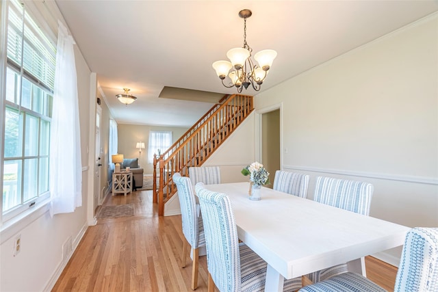 103 Woods Ave, Malverne, NY 11565 - dining room featuring stairs, a chandelier, light wood-style floors, and baseboards