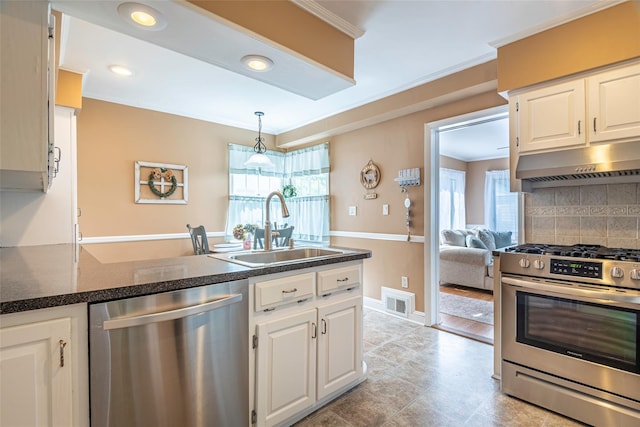 103 Woods Ave, Malverne, NY 11565 - kitchen with appliances with stainless steel finishes, a sink, under cabinet range hood, backsplash, and white cabinets