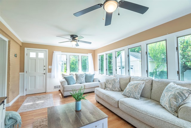 103 Woods Ave, Malverne, NY 11565 - living room with a ceiling fan, crown molding, a wainscoted wall, and light wood-style flooring
