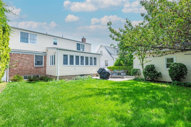 103 Woods Ave, Malverne, NY 11565 - rear view of house featuring a patio area, a chimney, and a lawn