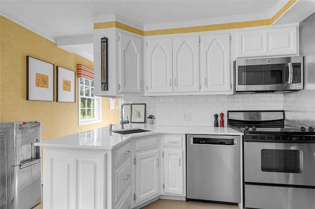 5 Seaview Ln, Port Washington, NY 11050 - kitchen featuring appliances with stainless steel finishes, a sink, light countertops, crown molding, and white cabinetry