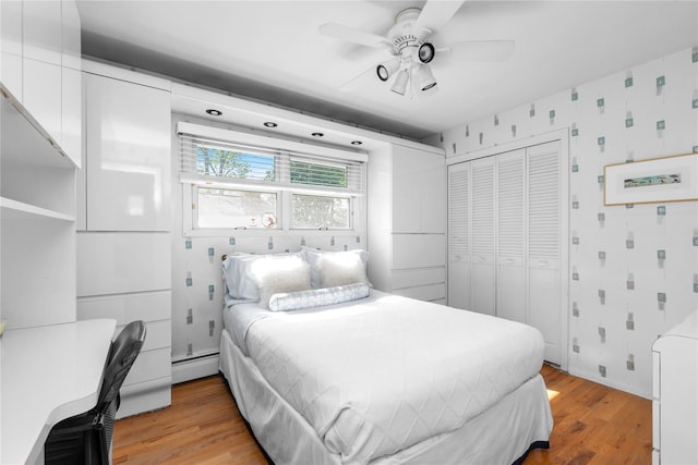 5 Seaview Ln, Port Washington, NY 11050 - bedroom with light wood-style flooring, a closet, baseboard heating, wallpapered walls, and ceiling fan