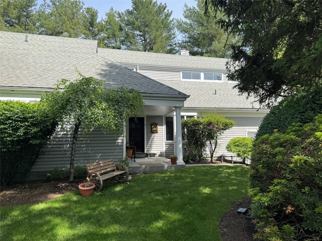 2 Greenwood Ct, Briarcliff Manor, NY 10510 - view of front of property featuring roof with shingles, a front yard, and a chimney