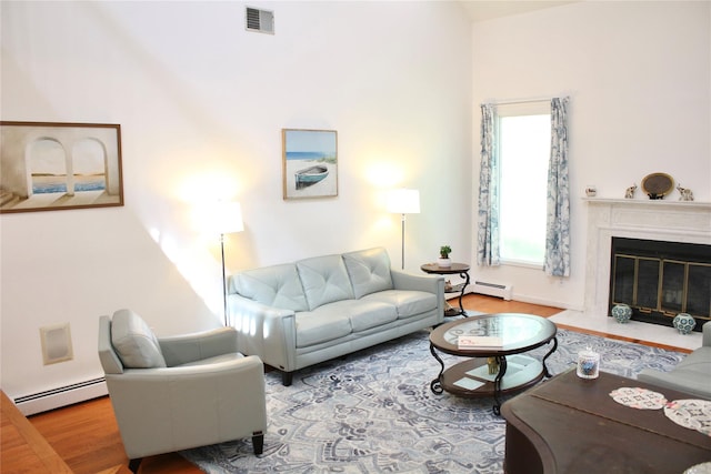 2 Greenwood Ct, Briarcliff Manor, NY 10510 - living room with a baseboard heating unit, wood finished floors, and a fireplace with flush hearth