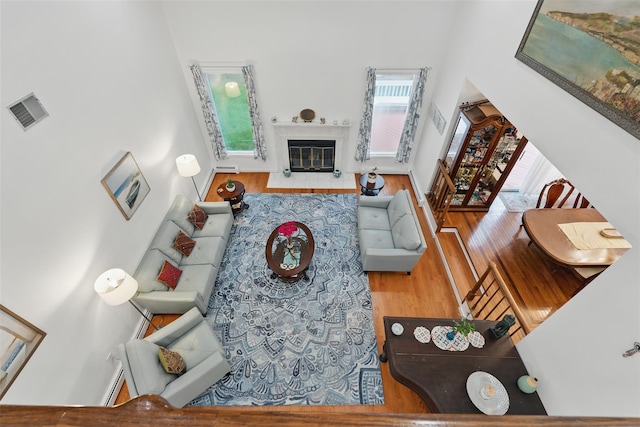 2 Greenwood Ct, Briarcliff Manor, NY 10510 - living area with a towering ceiling, wood finished floors, plenty of natural light, and a fireplace with flush hearth
