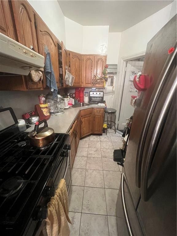 5910 Beverley Rd, Brooklyn, NY 11203 - kitchen with appliances with stainless steel finishes, range hood, light tile patterned floors, and light countertops