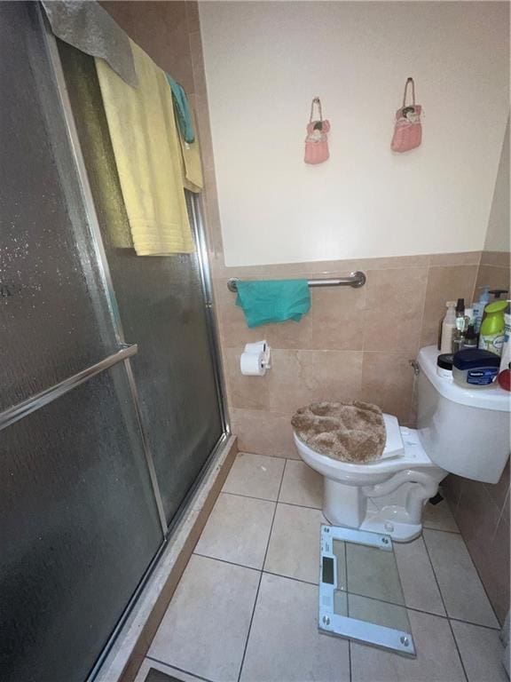 5910 Beverley Rd, Brooklyn, NY 11203 - full bathroom featuring toilet, tile walls, a stall shower, tile patterned flooring, and wainscoting