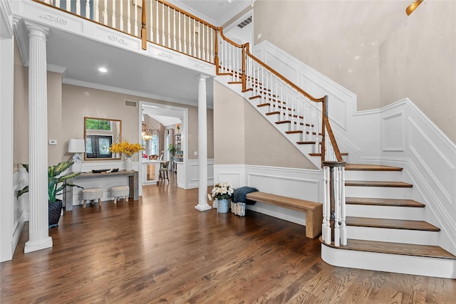 11 Crick Holly Ln, East Islip, NY 11730 - staircase with decorative columns, wood finished floors, a high ceiling, a decorative wall, and ornamental molding