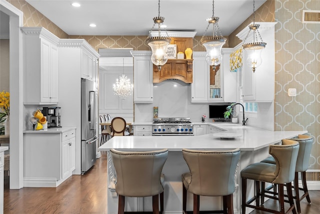 11 Crick Holly Ln, East Islip, NY 11730 - kitchen with high end appliances, wallpapered walls, dark wood finished floors, light countertops, and a peninsula