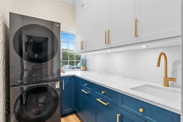 11 Crick Holly Ln, East Islip, NY 11730 - laundry area with stacked washer / drying machine, cabinet space, and light wood-style flooring