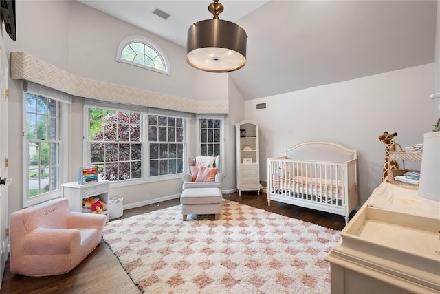 11 Crick Holly Ln, East Islip, NY 11730 - bedroom featuring wood finished floors, a crib, high vaulted ceiling, and baseboards