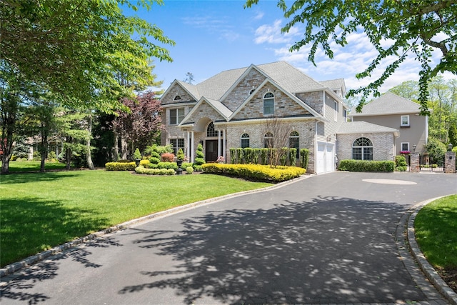 11 Crick Holly Ln, East Islip, NY 11730 - view of front of home with driveway, brick siding, a front yard, an attached garage, and stone siding