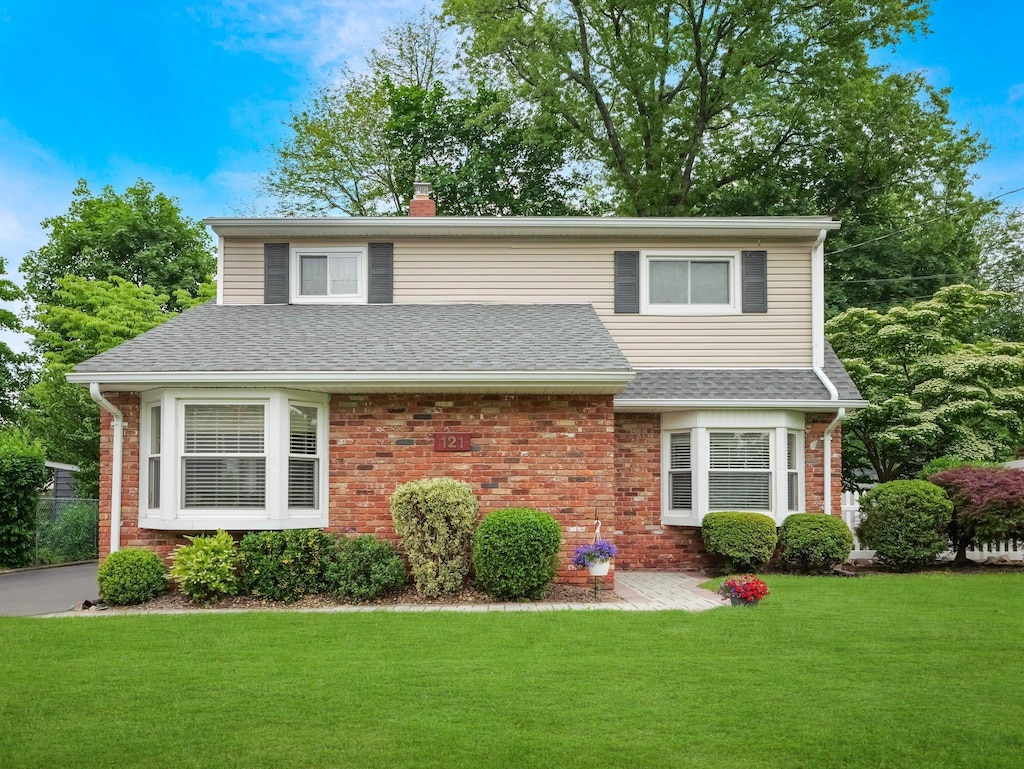 121 Bogert Ave, Pearl River, NY 10965 - traditional home with brick siding, a front lawn, a chimney, and a shingled roof