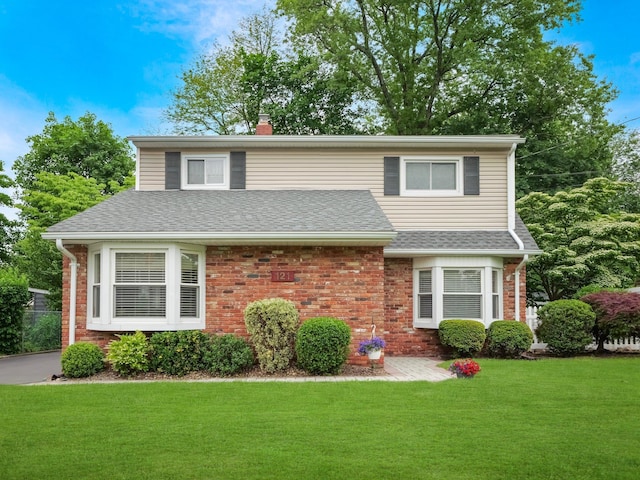 121 Bogert Ave, Pearl River, NY 10965 - traditional home with brick siding, a front lawn, a chimney, and a shingled roof